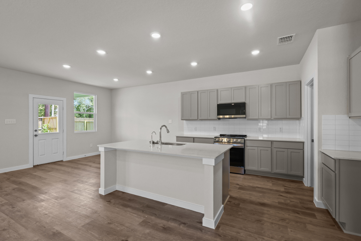 A kitchen with white cabinets.