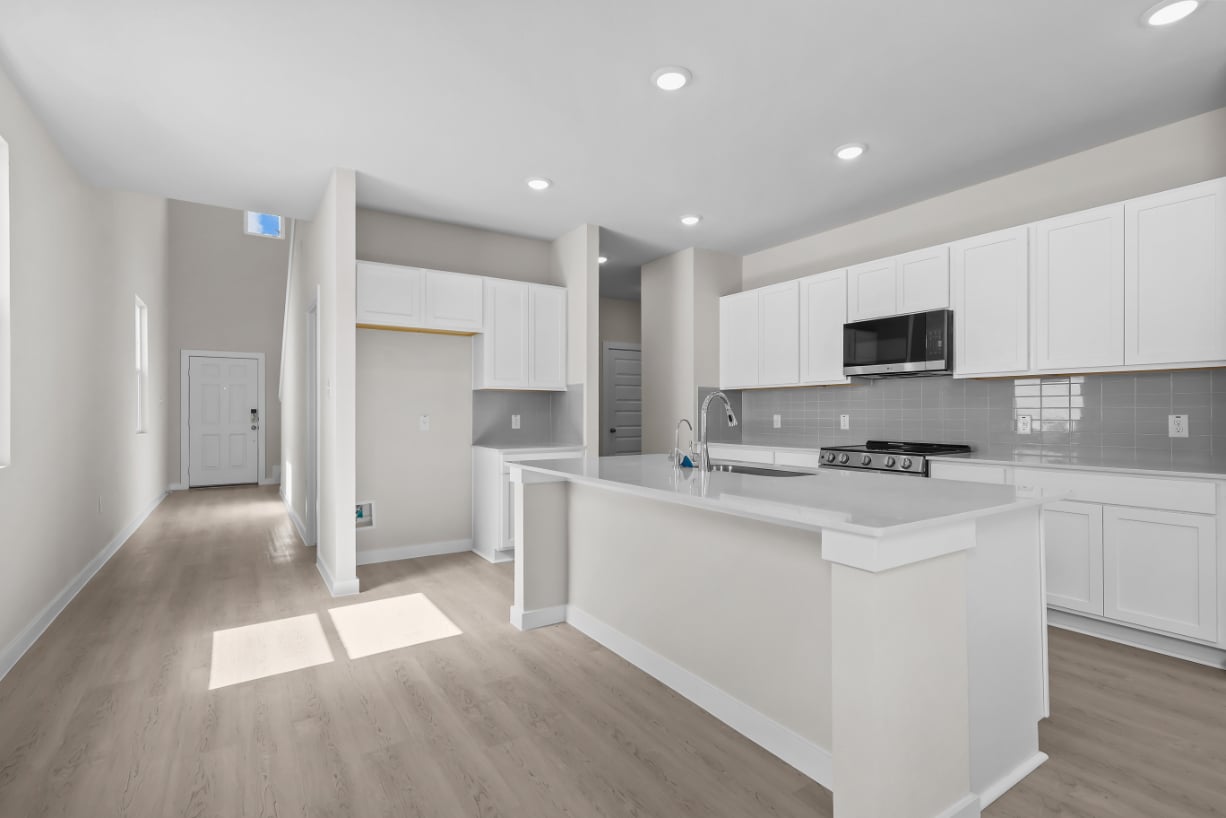 A kitchen with white cabinets.