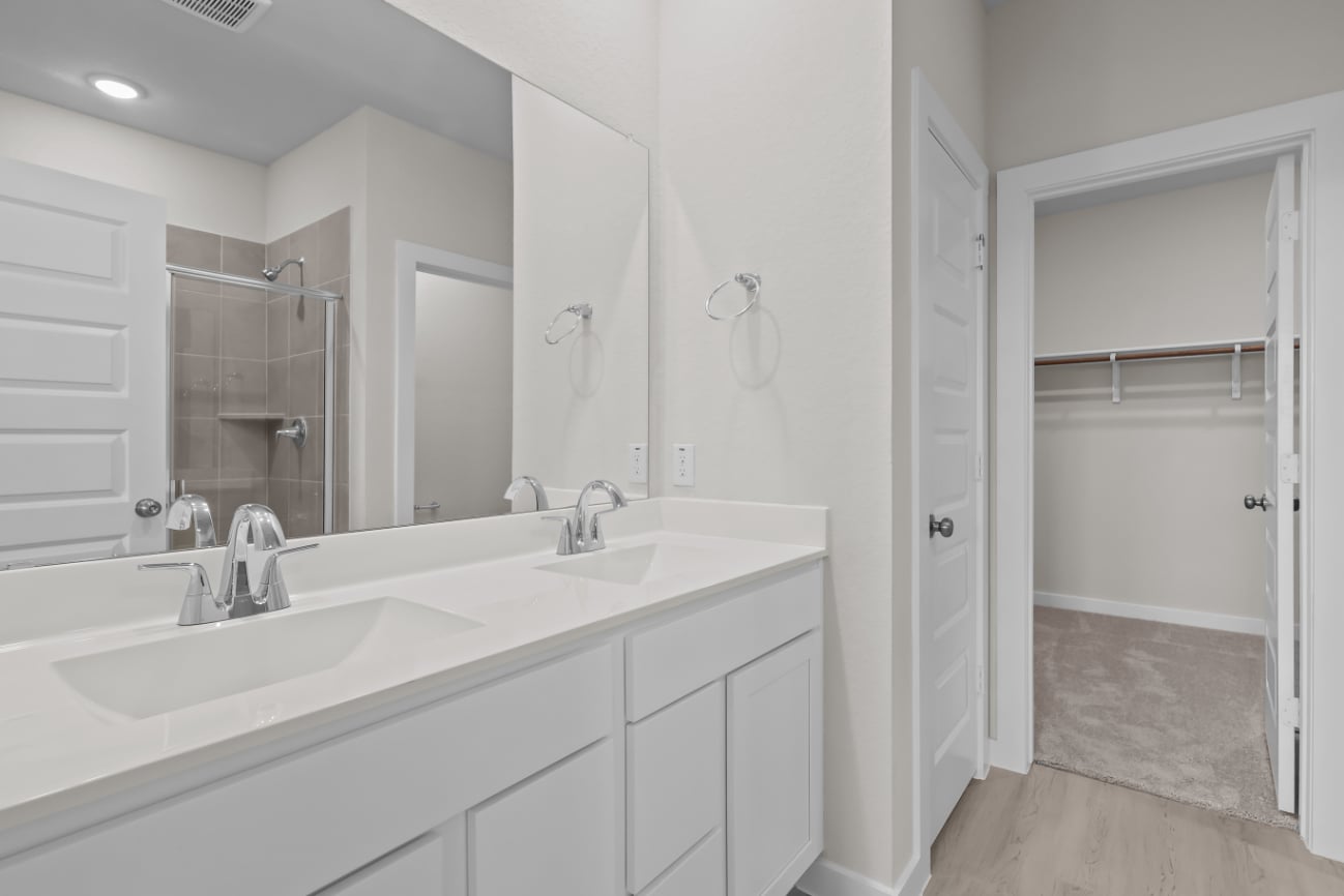 A bathroom with a sink and a shower unit.