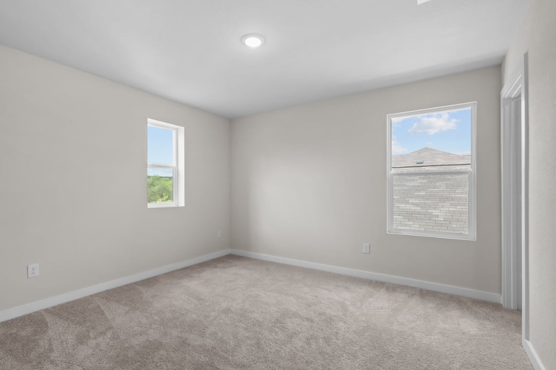 A room with a carpet and a window.