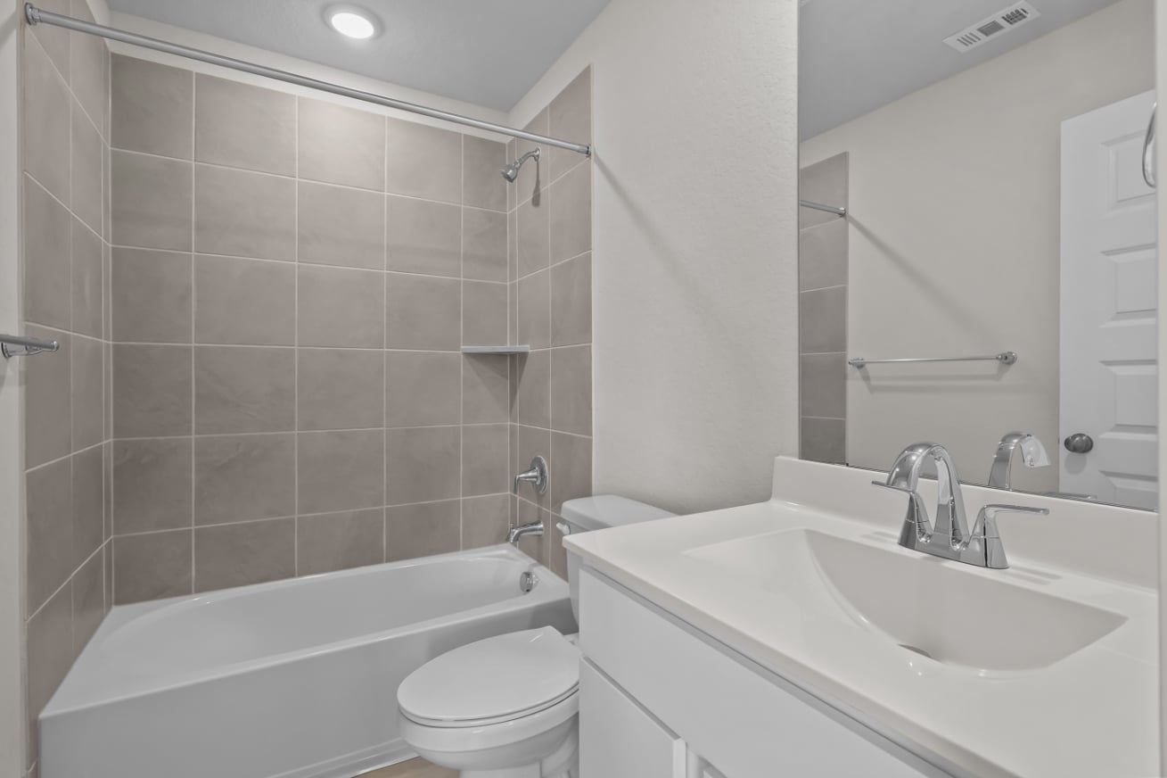 A bathroom with a tub sink and toilet.