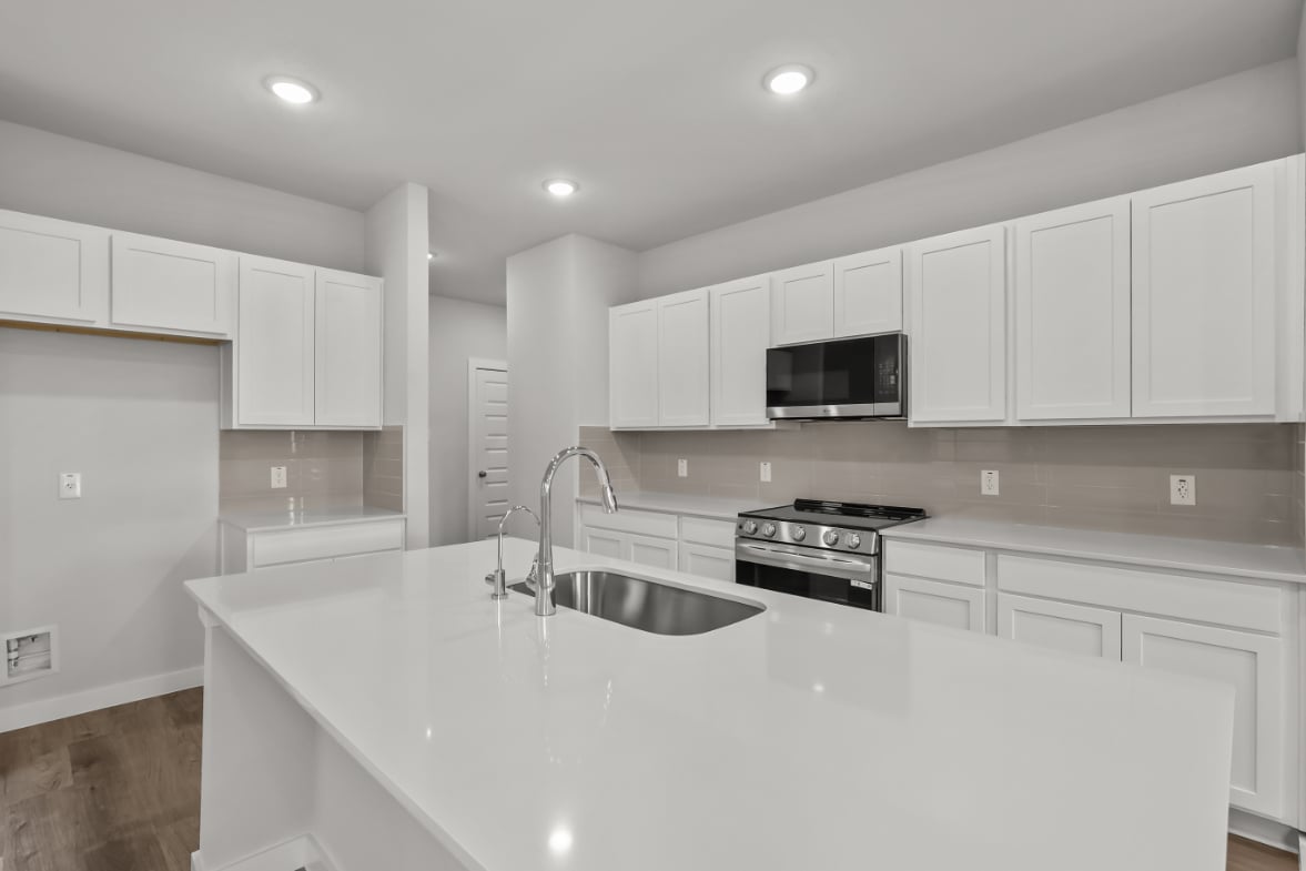 A kitchen with white cabinets.