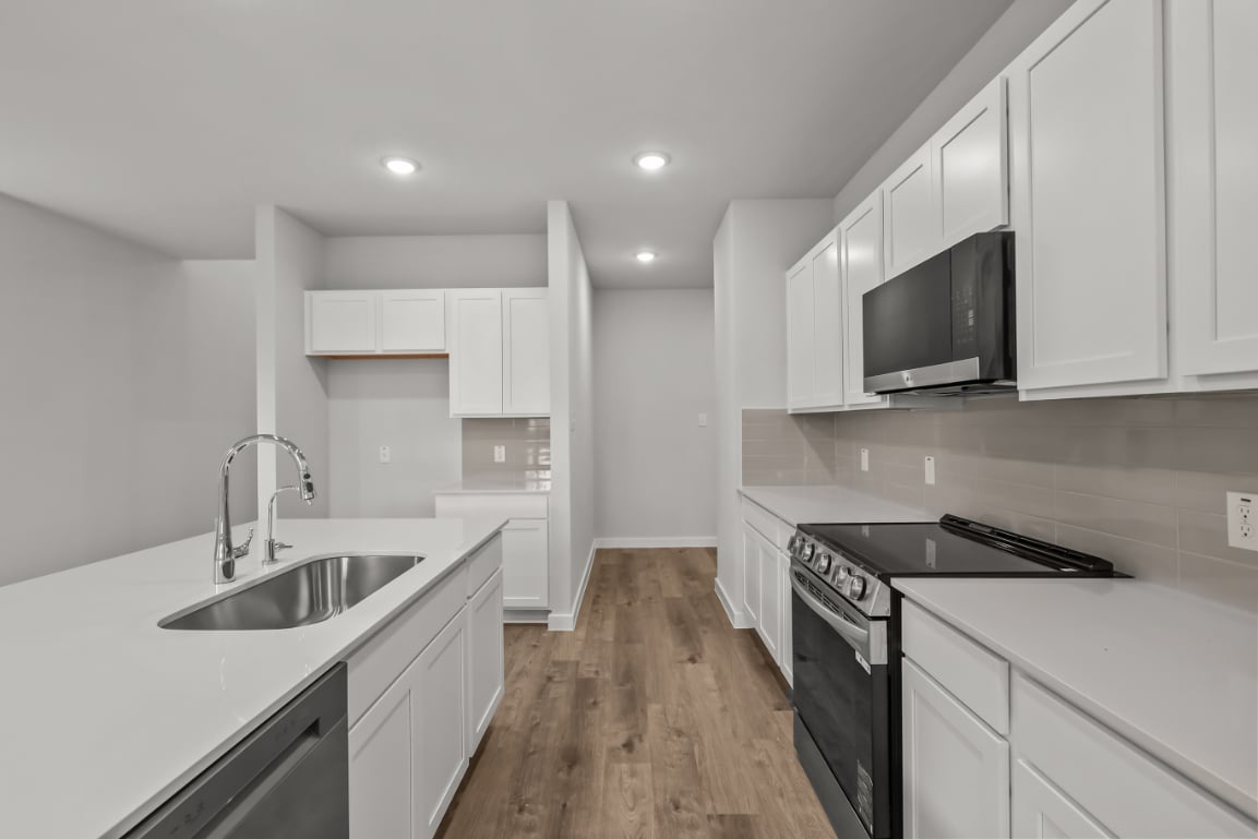 A kitchen with white cabinets.