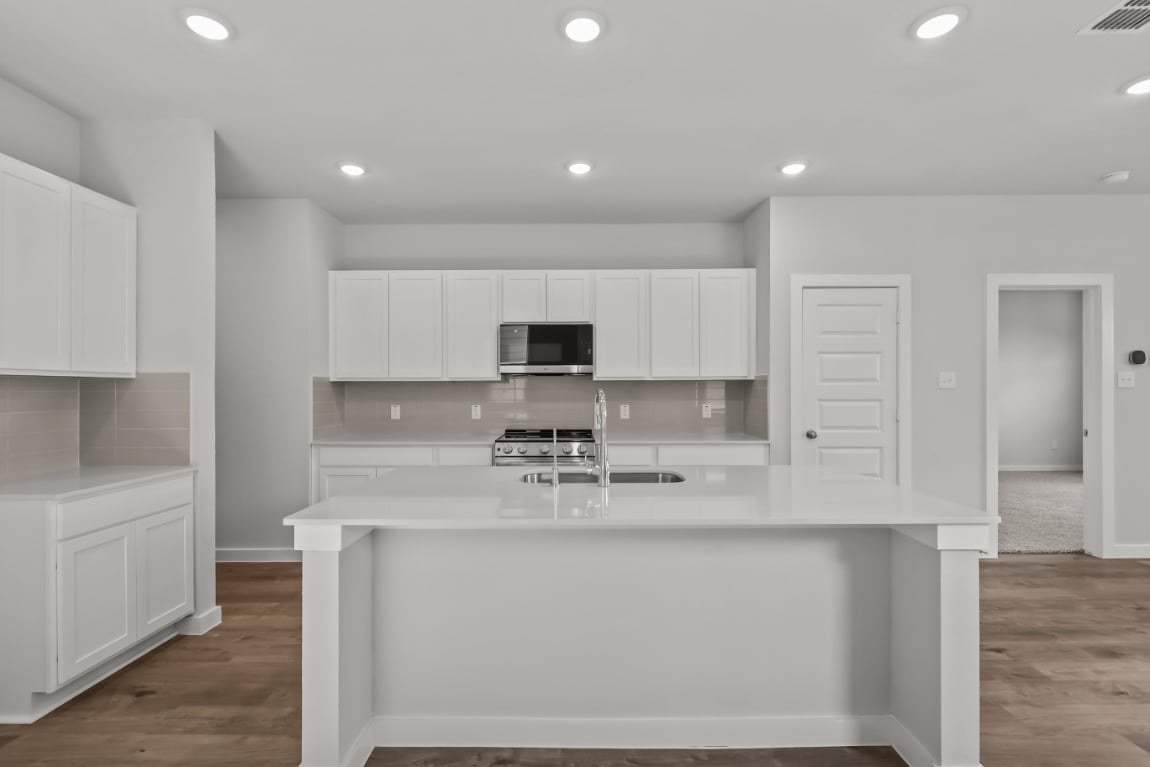 A kitchen with white cabinets.