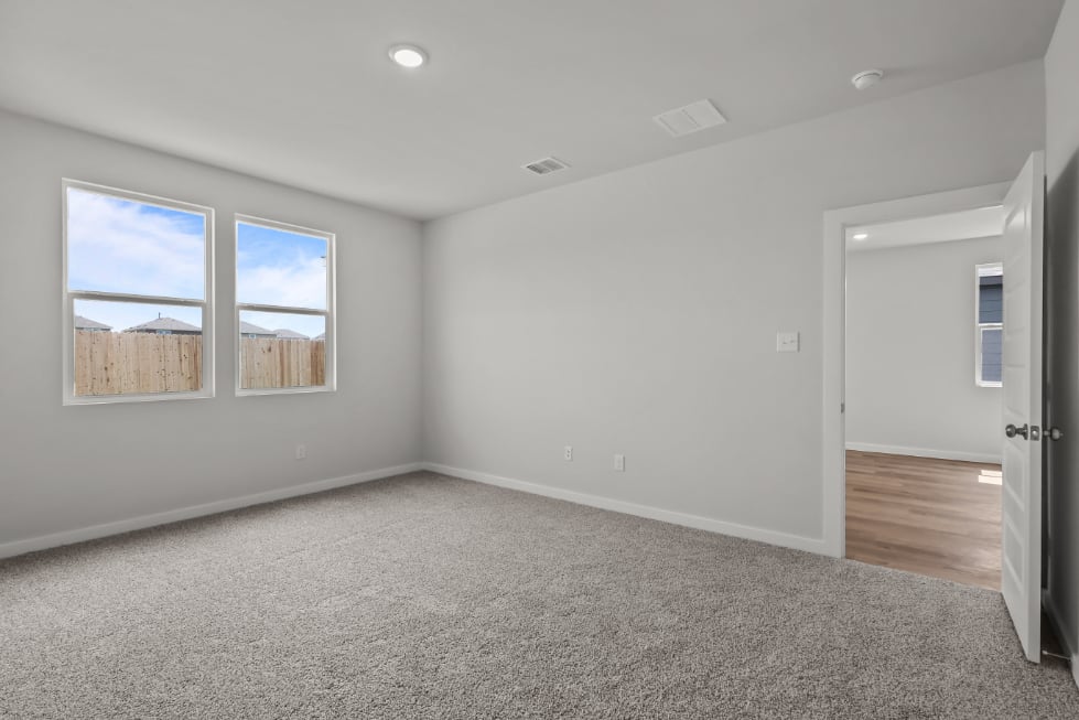 A room with a carpet and a door.