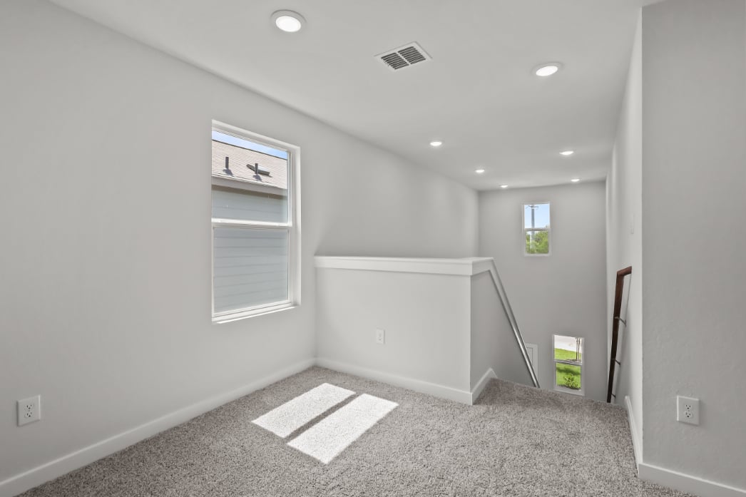 A room with a rug and a window.