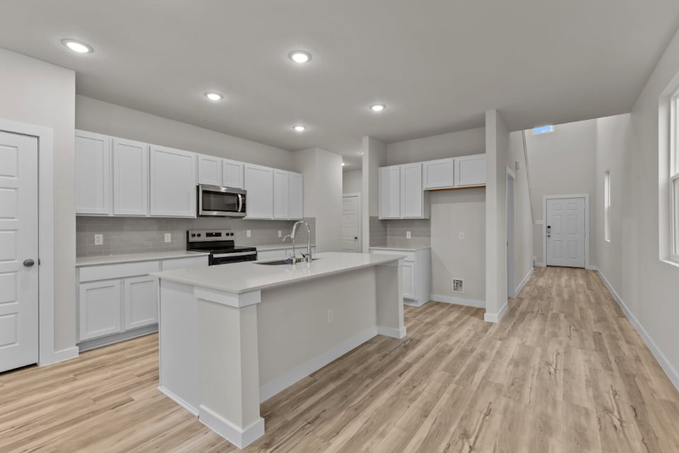 A kitchen with white cabinets.