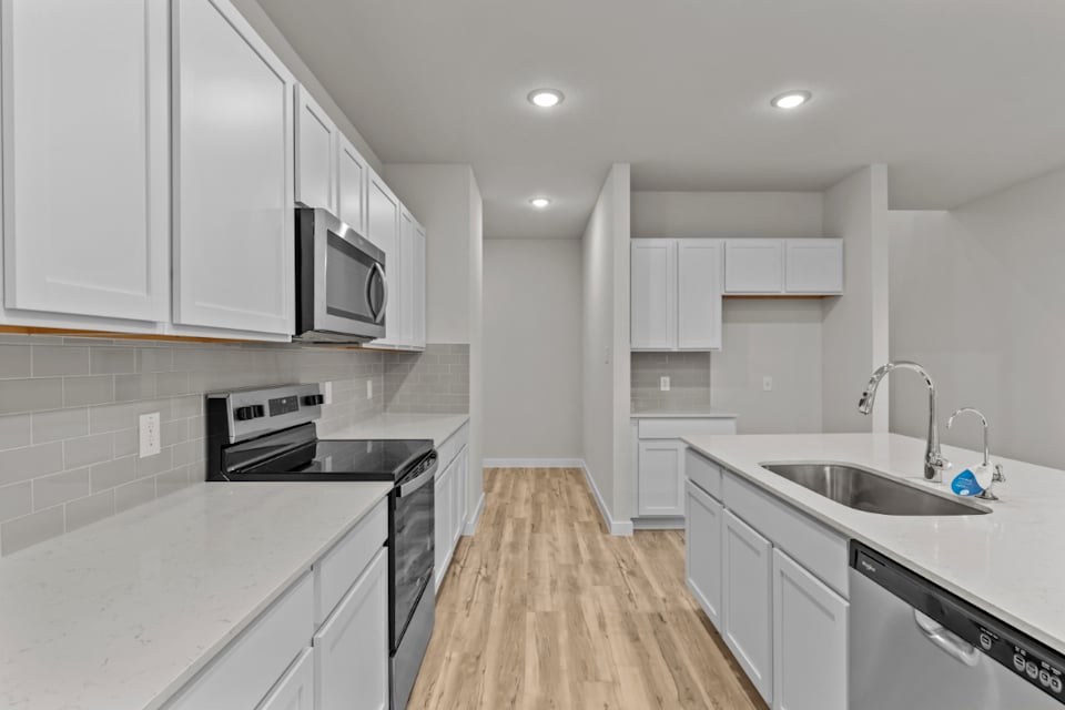 A kitchen with white cabinets.