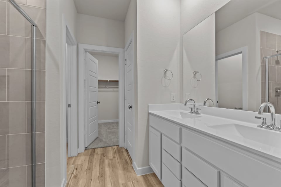 A bathroom with a sink and a shower unit.