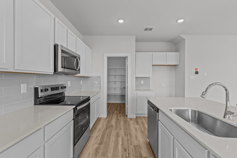 A kitchen with white cabinets.