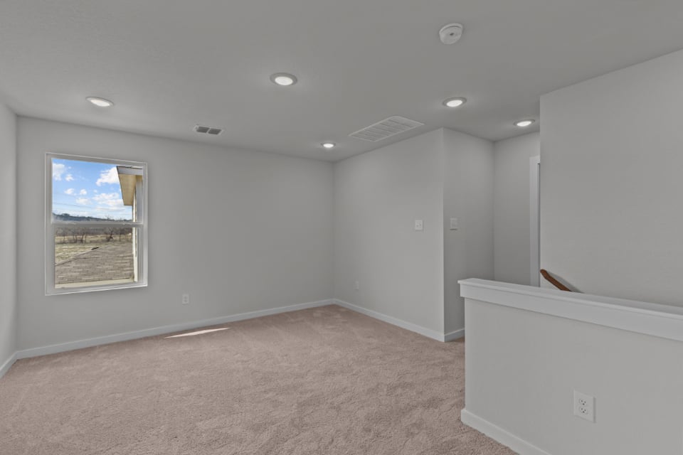 A room with a window and a rug.