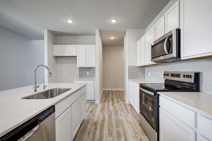 A kitchen with white cabinets.