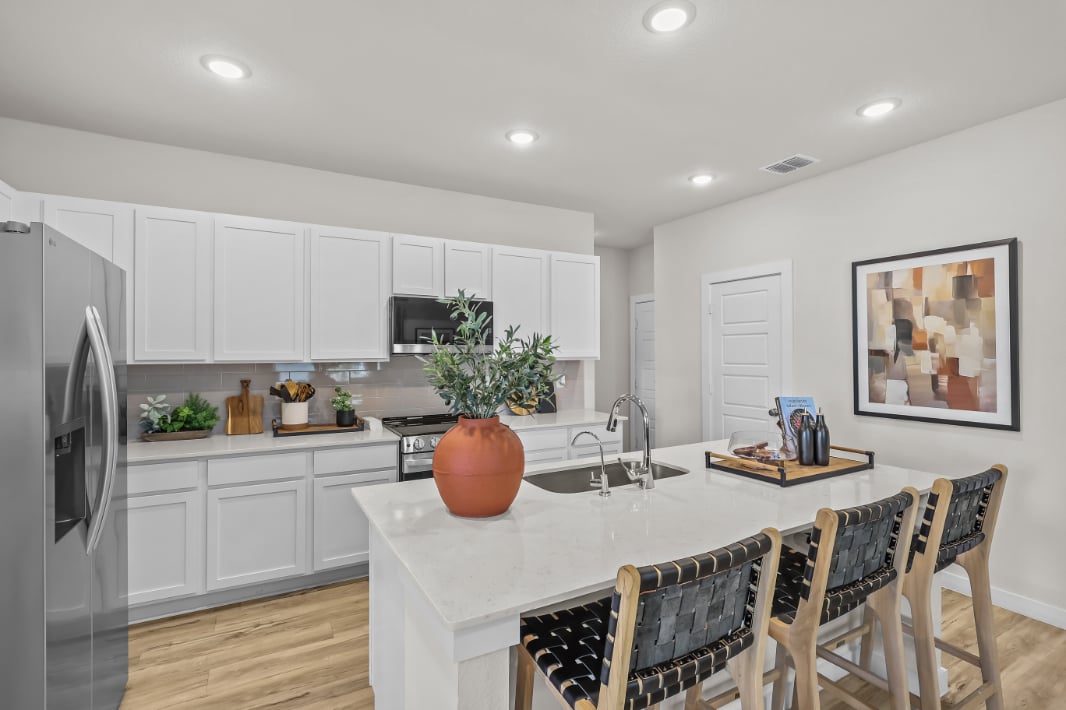 A kitchen with white cabinets.