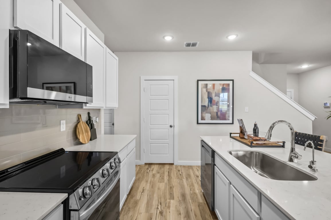 A kitchen with white cabinets.