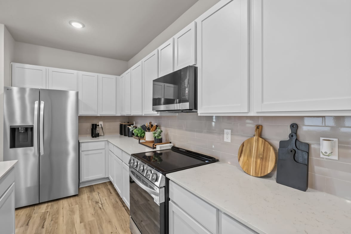 A kitchen with white cabinets.