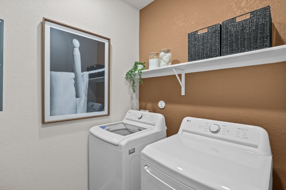 A white washing machine and a picture on a wall.