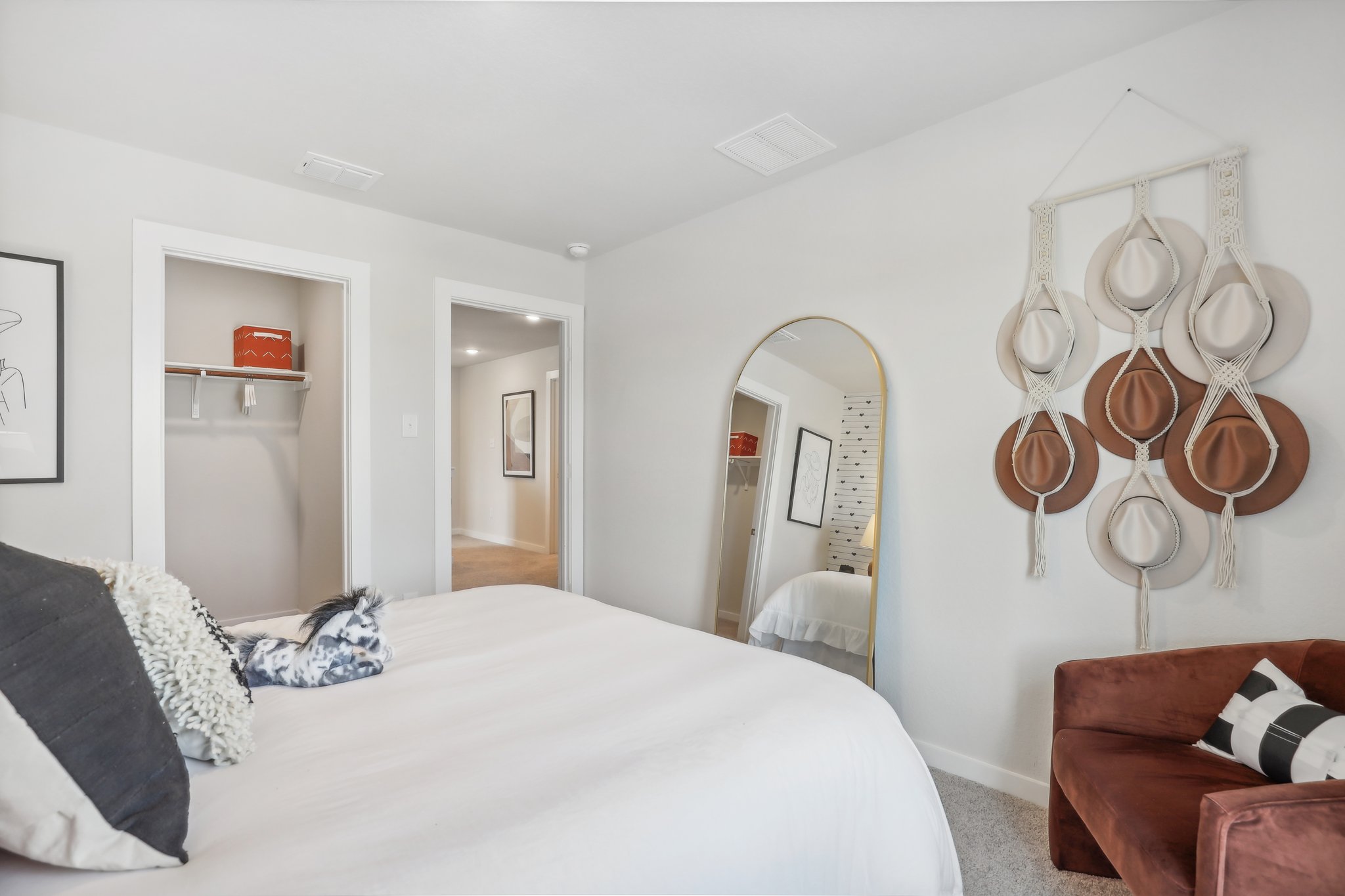 A bedroom with a bed and a mirror.