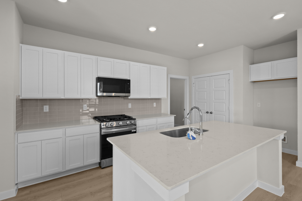 A kitchen with white cabinets.