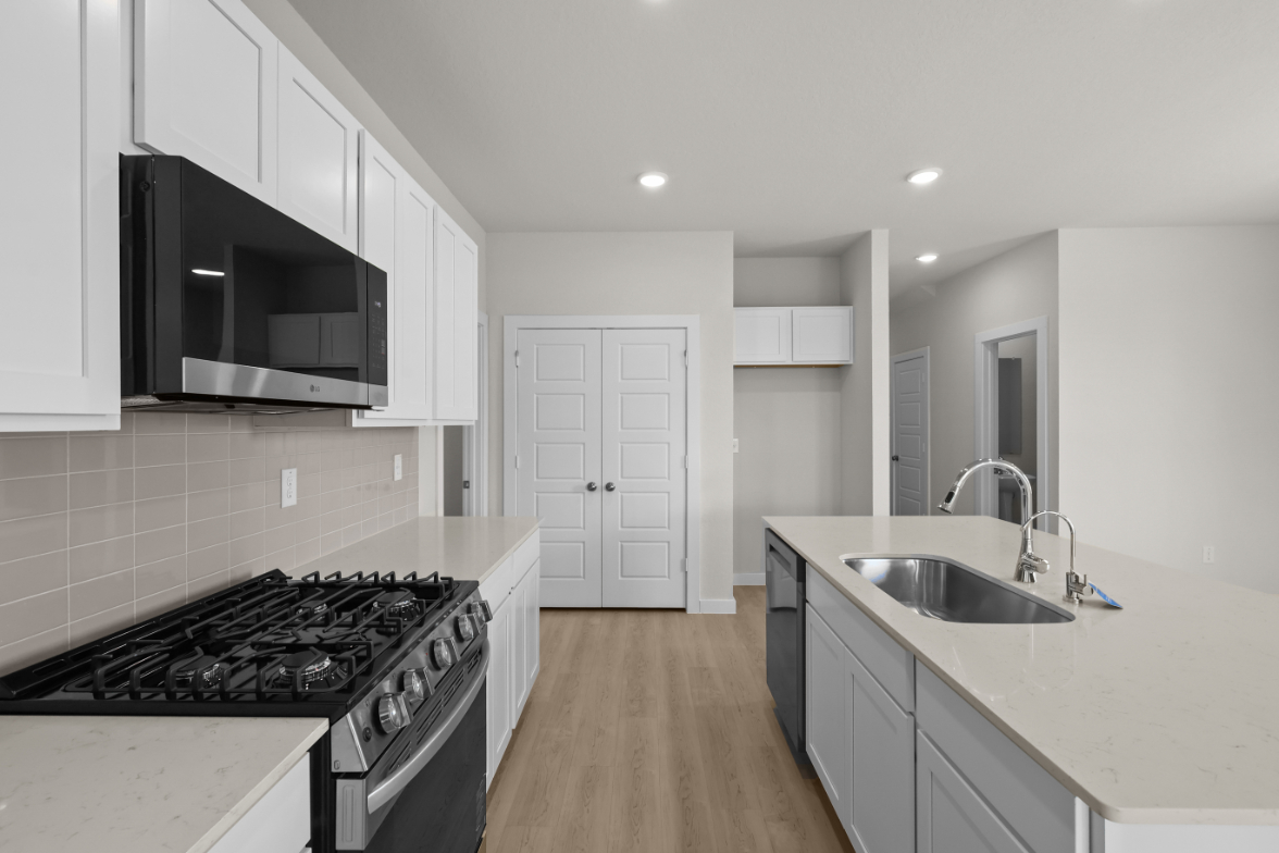 A kitchen with white cabinets.