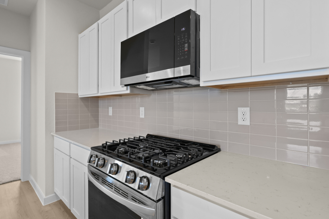 A kitchen with white cabinets.