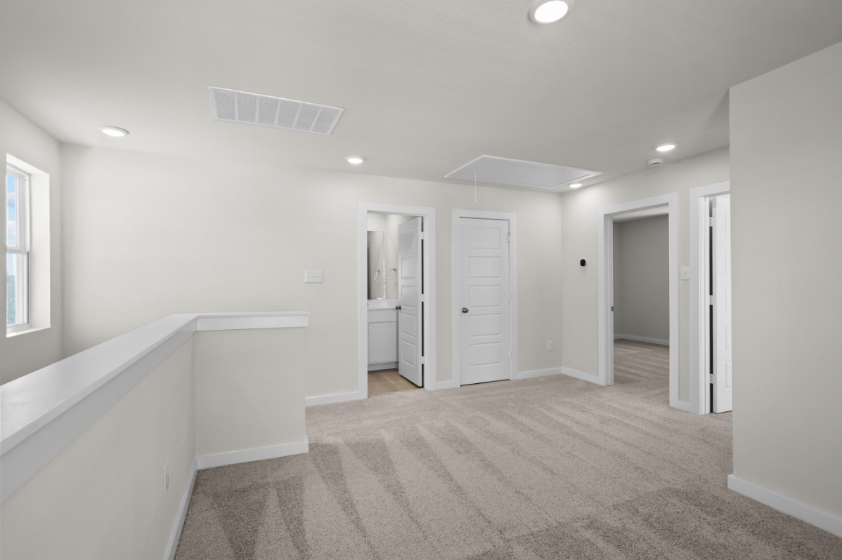 A long hallway with white doors.