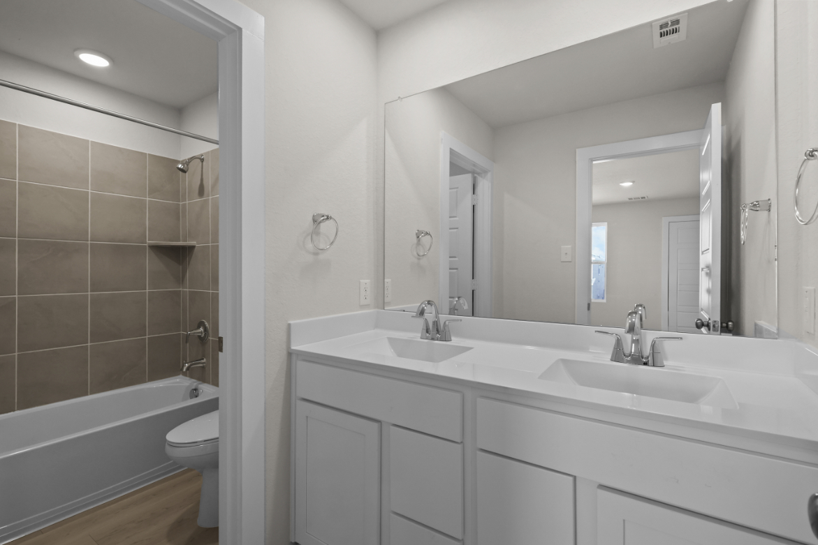 A bathroom with a tub sink and toilet.