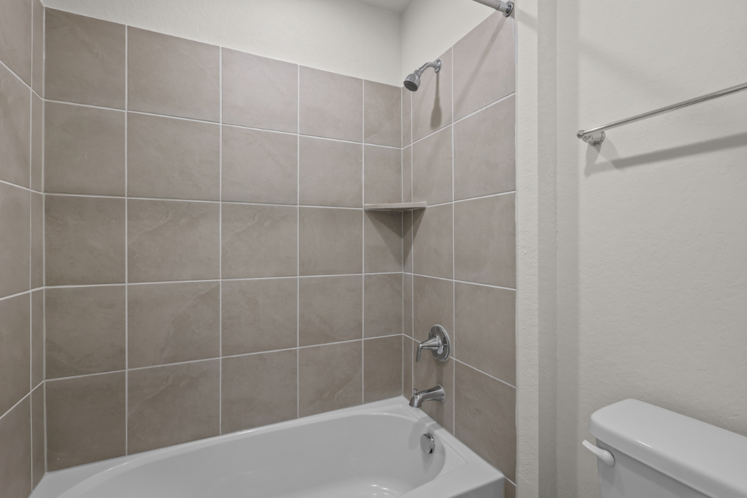 A bathroom with a bathtub and toilet.