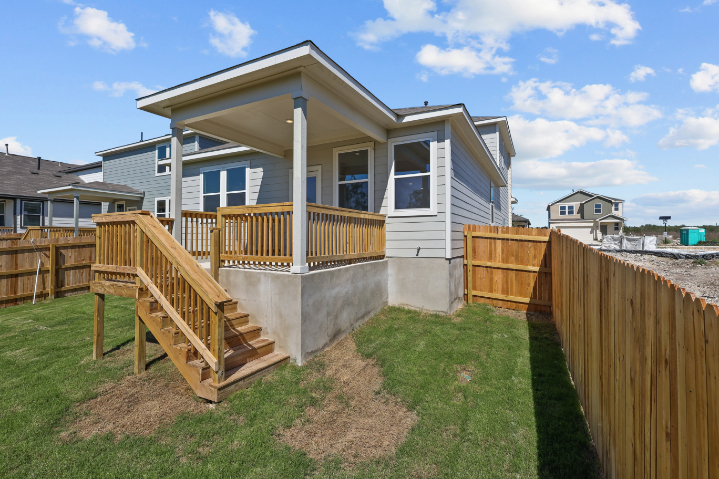 A house with a fence and a yard with a wood fence.