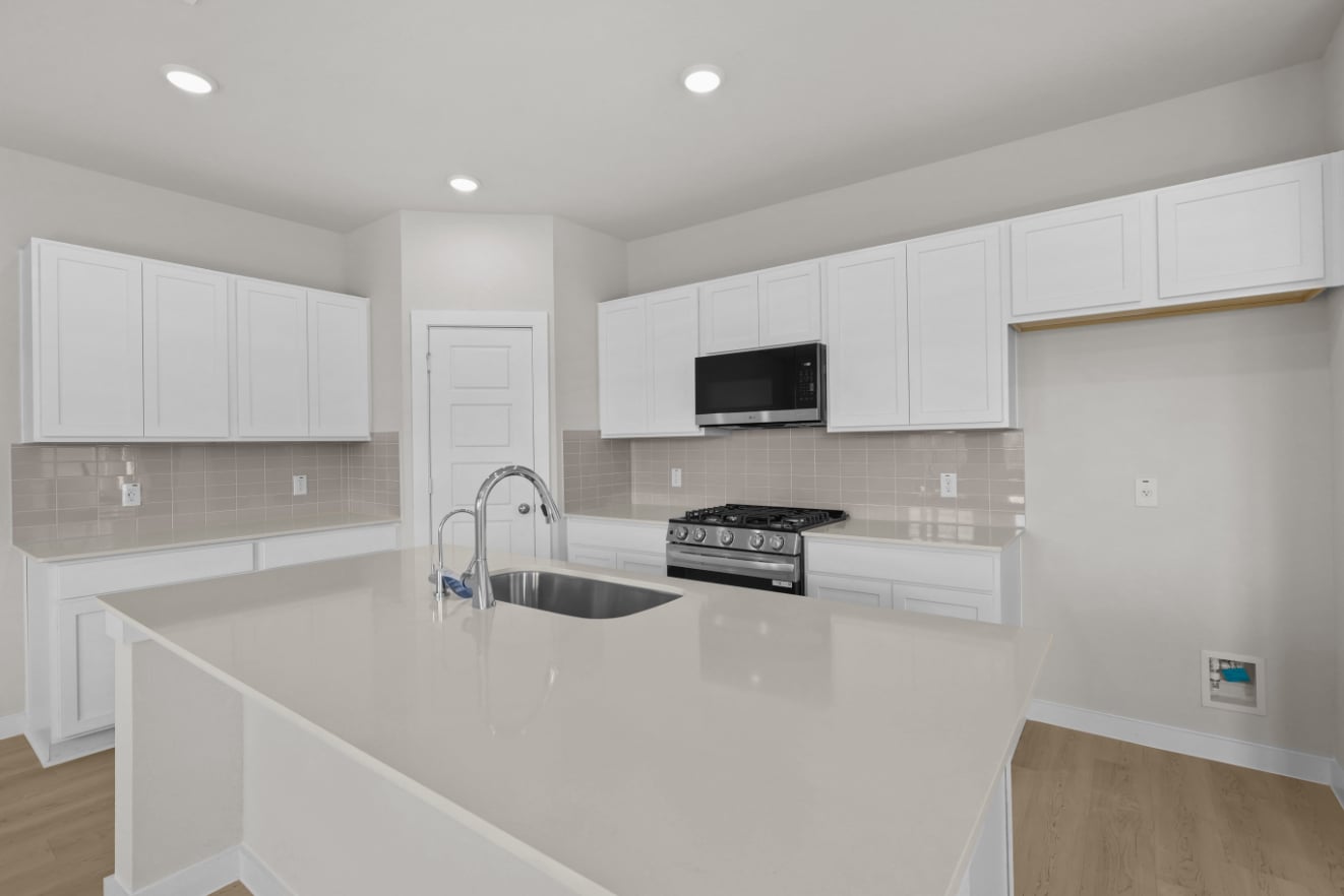 A kitchen with white cabinets.