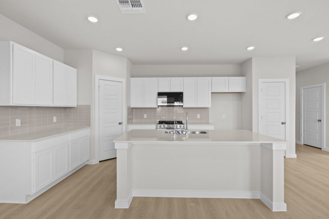 A kitchen with white cabinets.