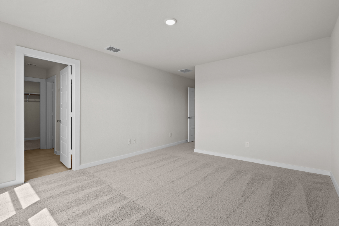 A room with a carpet and a door.
