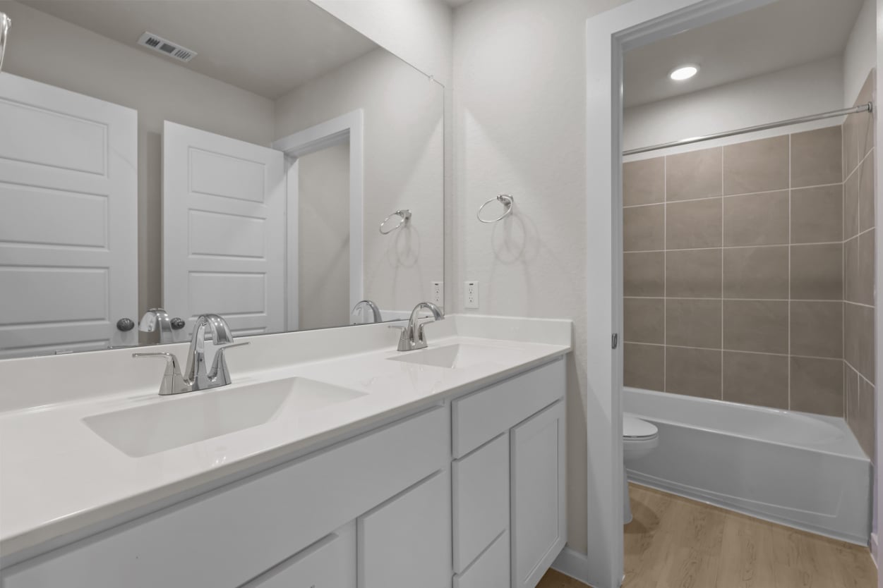 A bathroom with a tub sink and toilet.