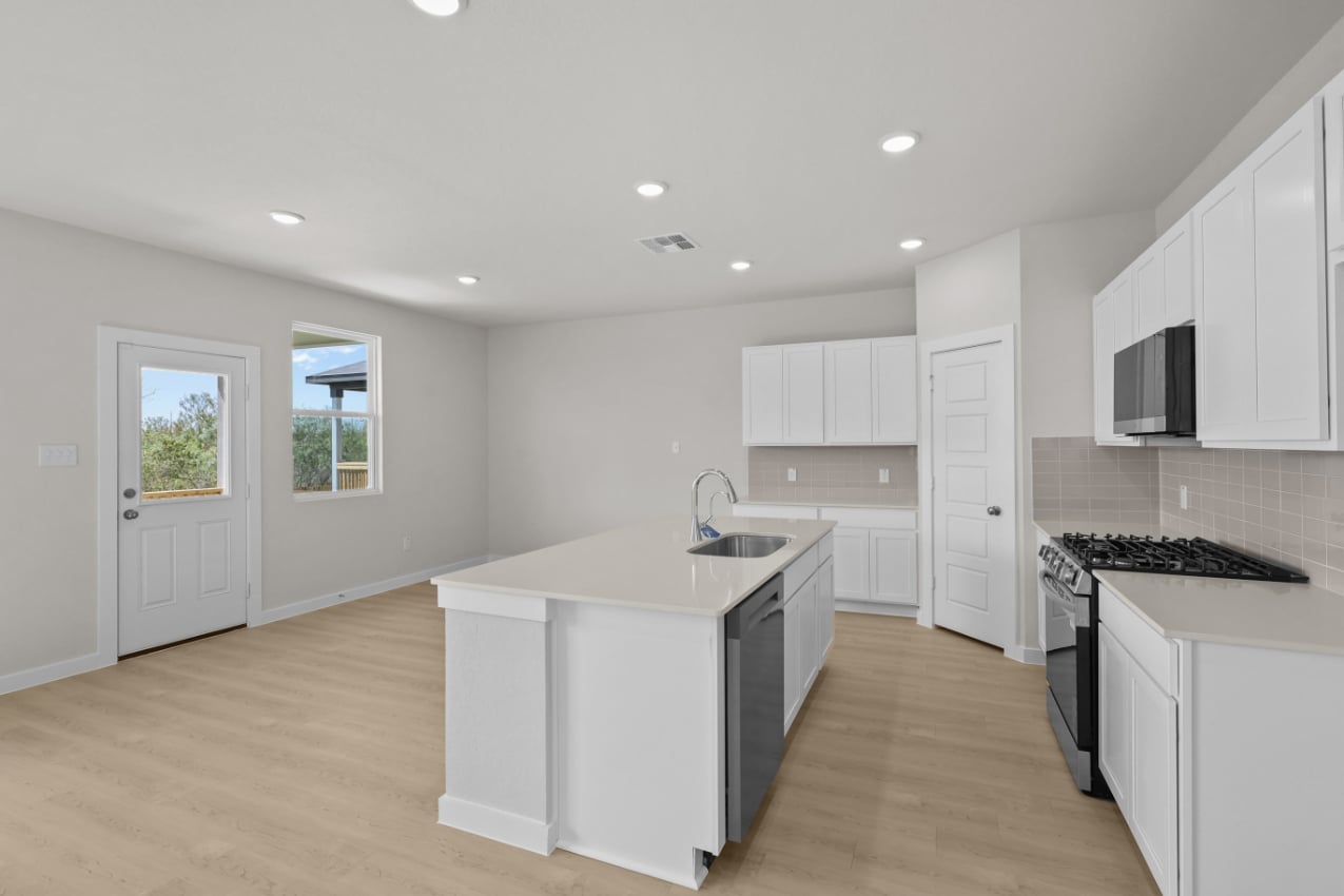 A kitchen with white cabinets.