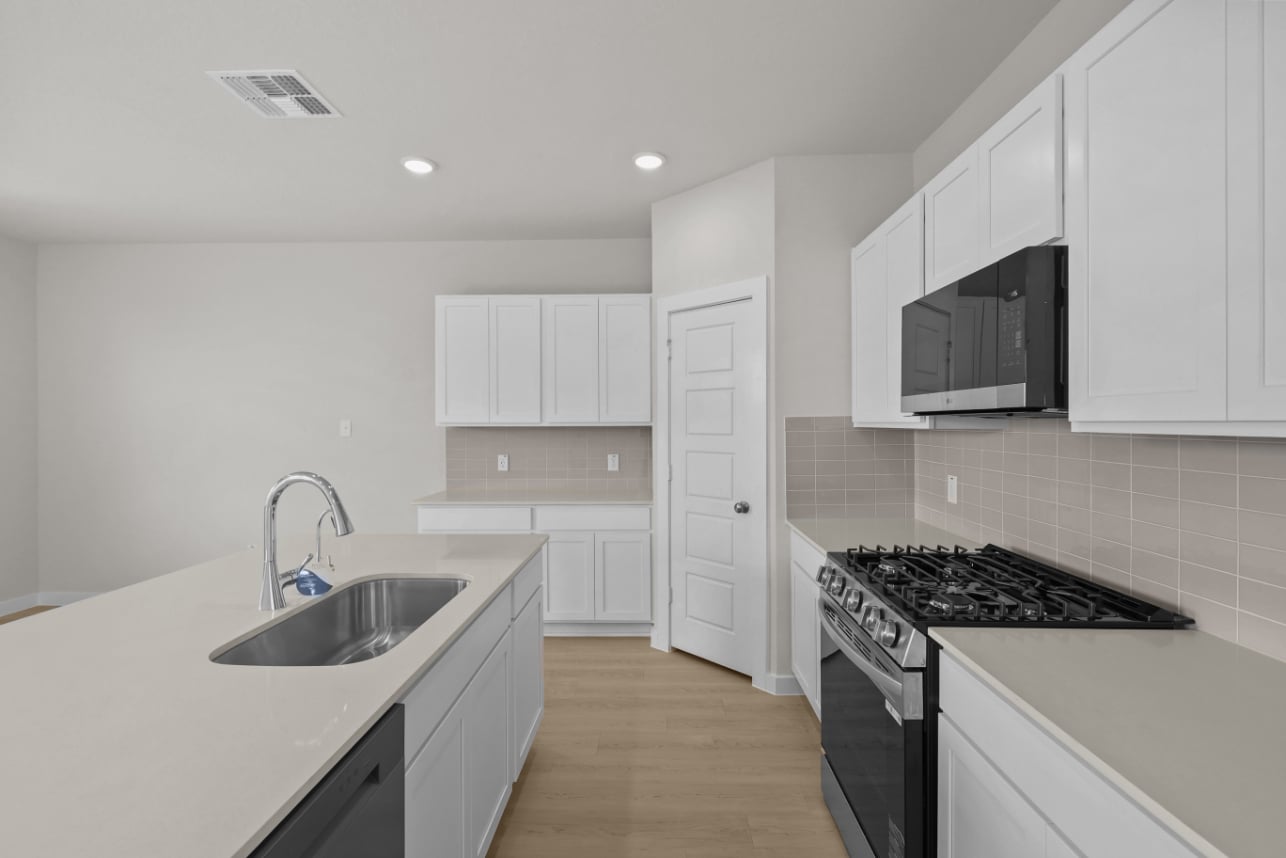 A kitchen with white cabinets.
