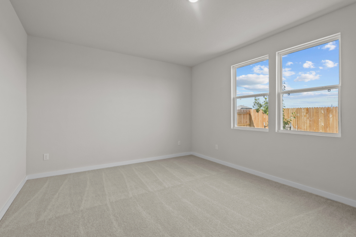 A room with a window and a rug.