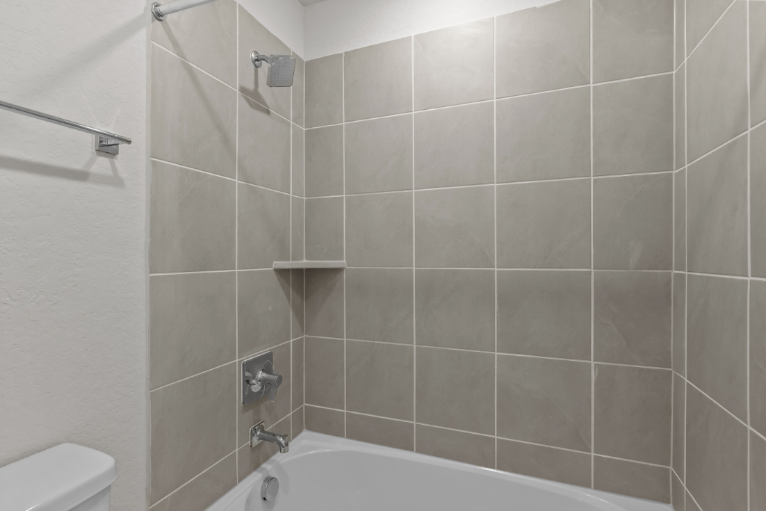 A bathroom with a bathtub and shower.