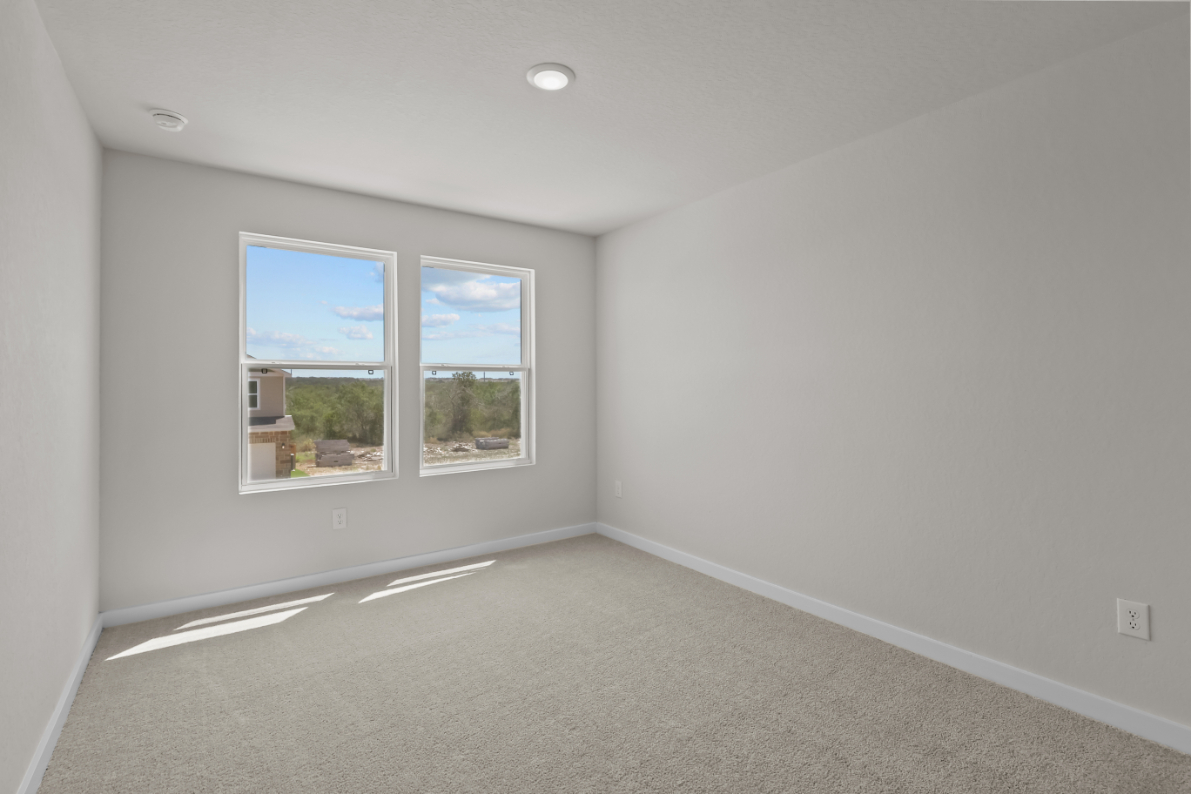 A room with a window and a carpet.