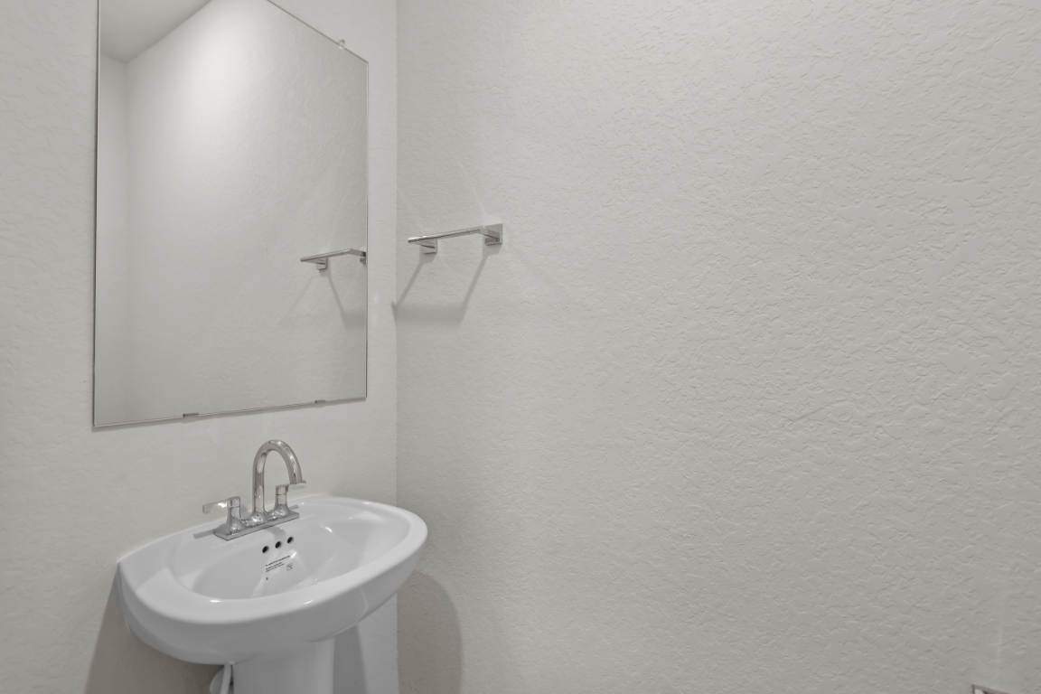 A bathroom with a mirror and sink.