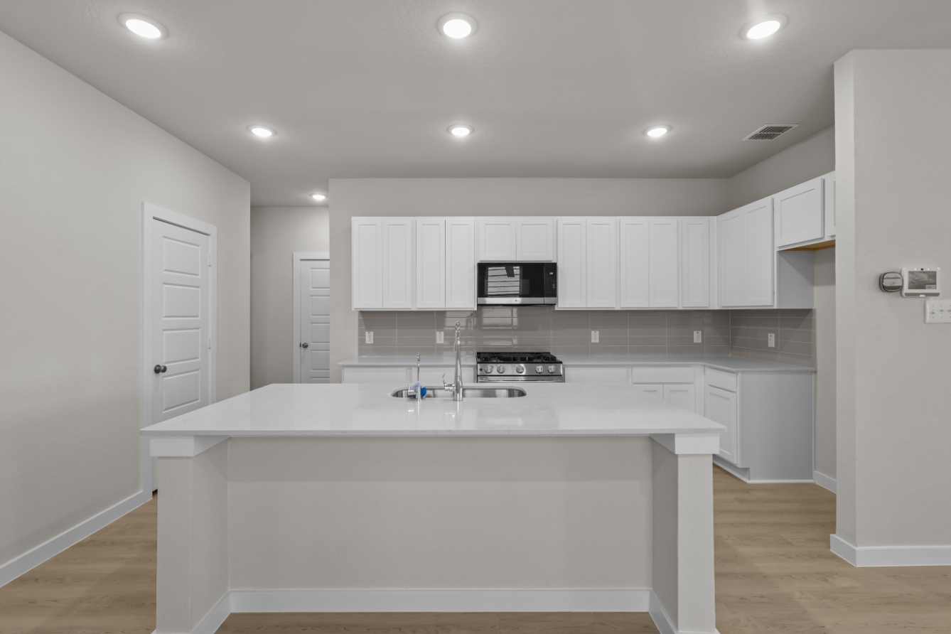 A kitchen with white cabinets.