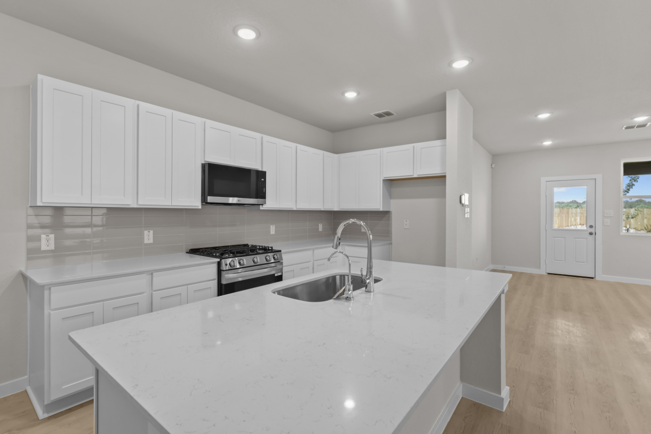 A kitchen with white cabinets.