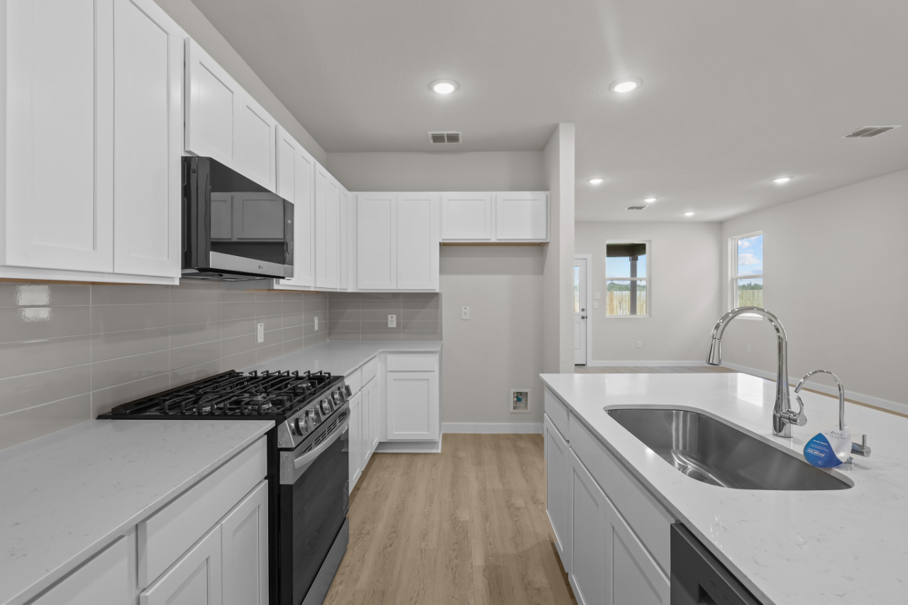 A kitchen with white cabinets.