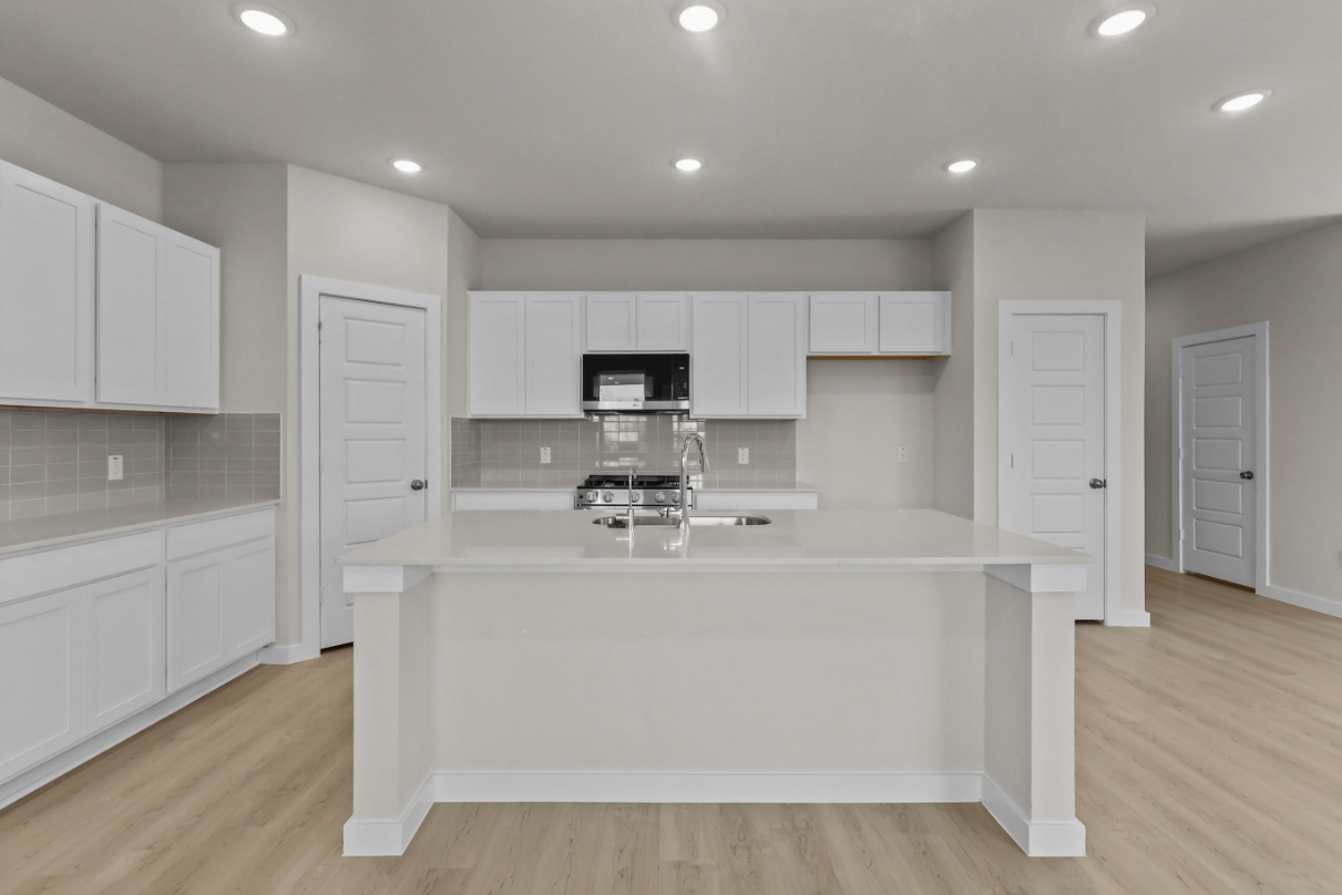 A kitchen with white cabinets.