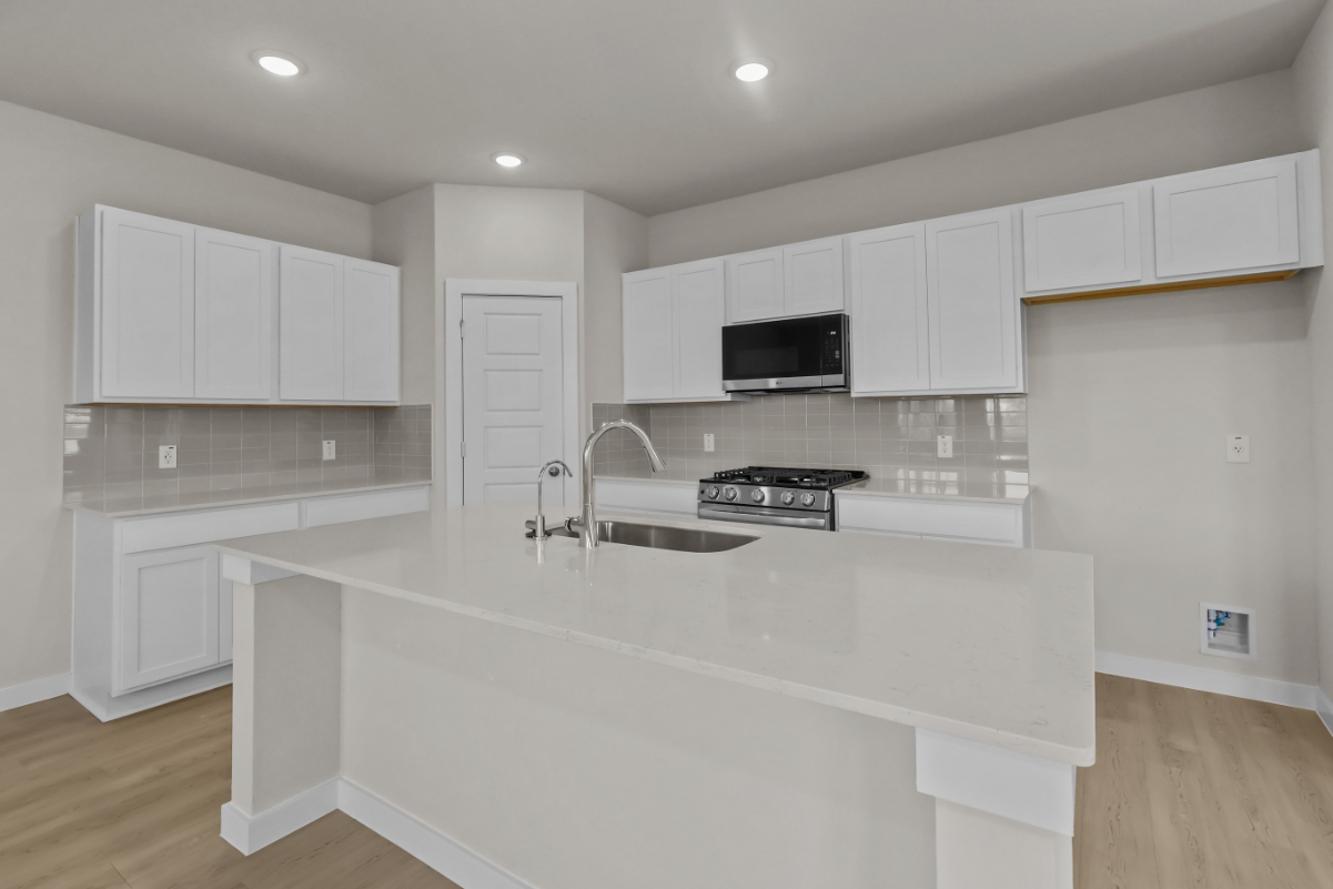 A kitchen with white cabinets.