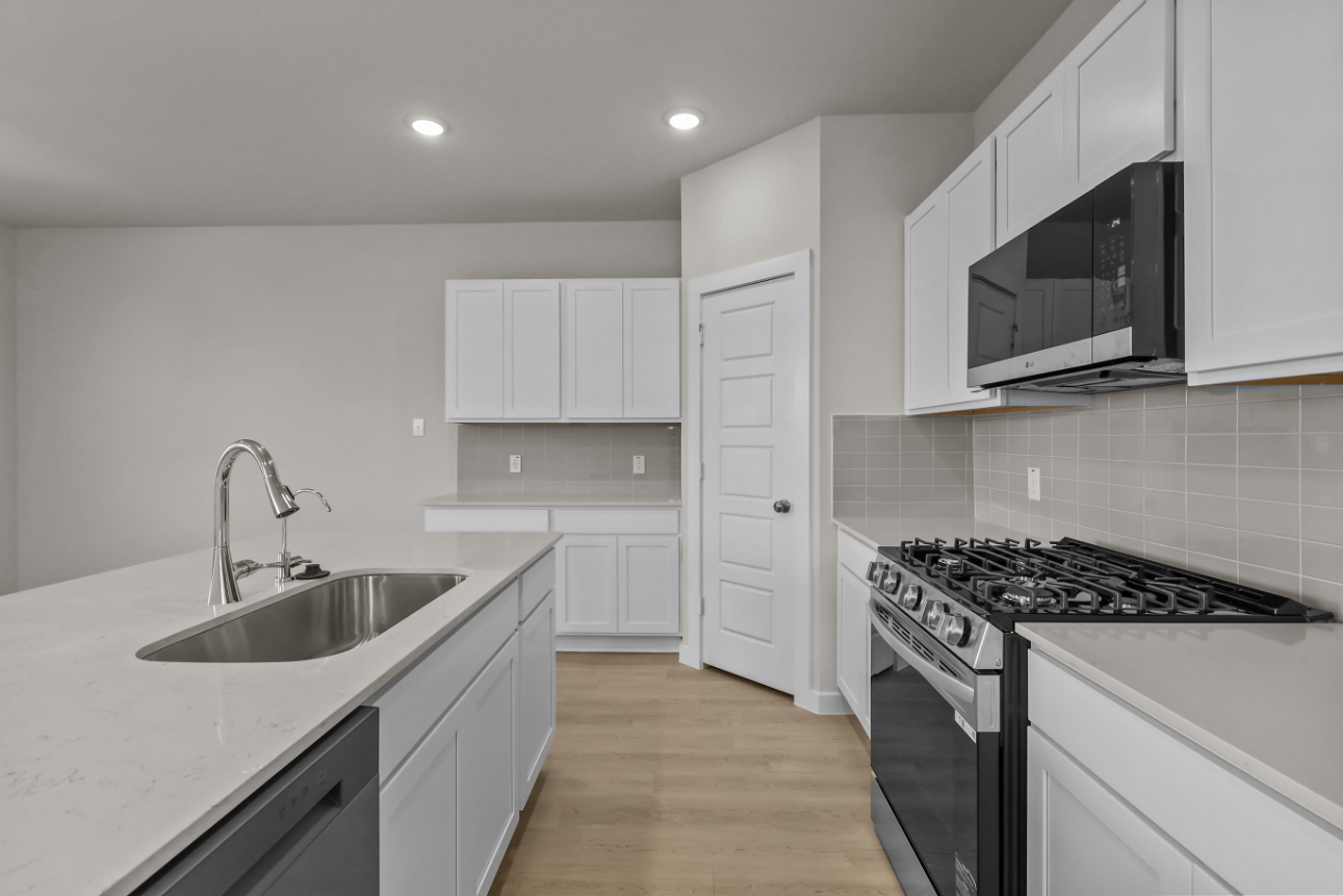 A kitchen with white cabinets.