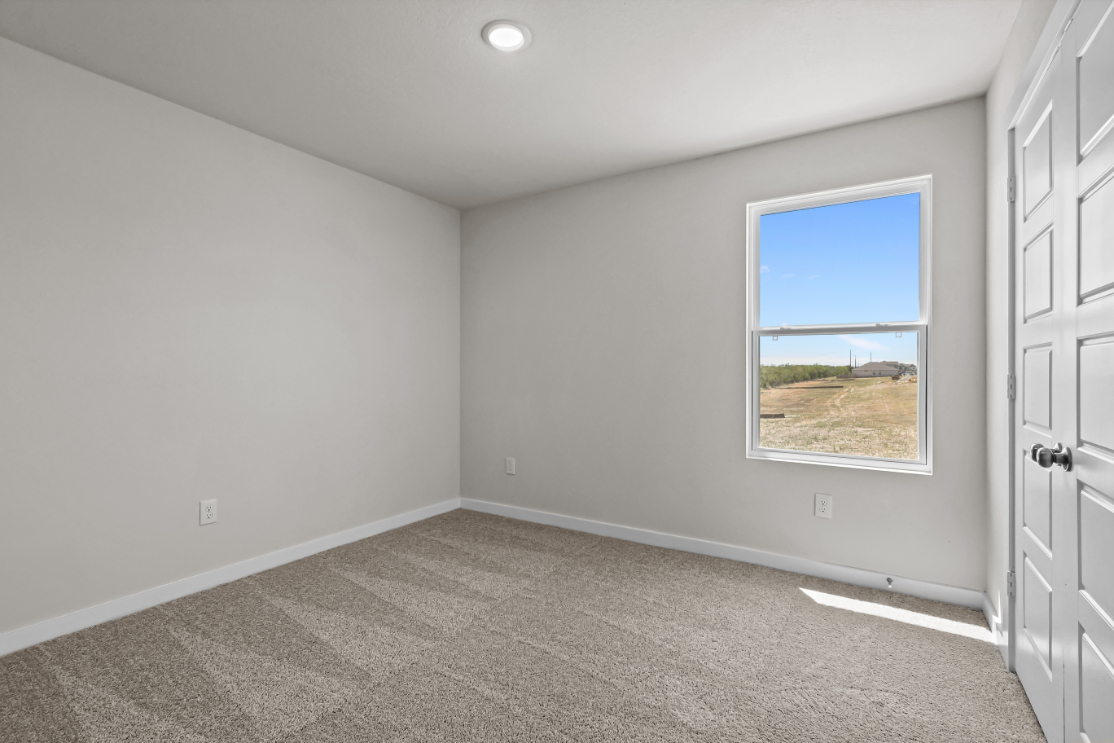 A room with a window and a carpet.