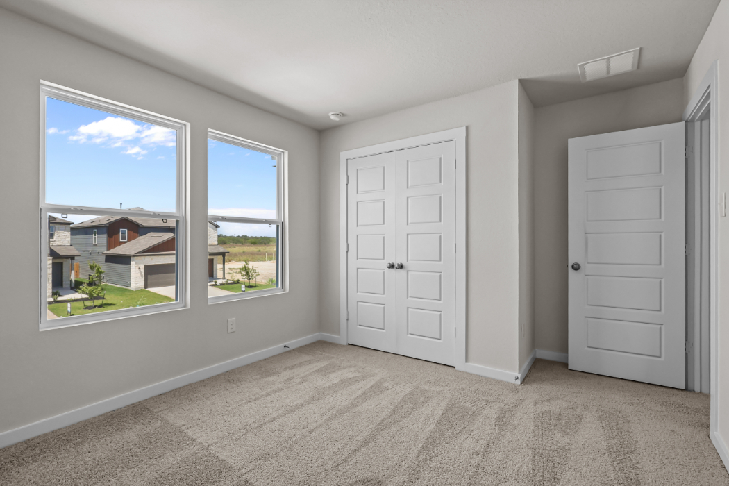 A room with white doors and a window with a view of a city.
