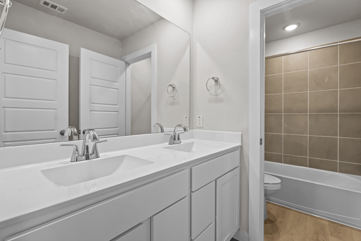 A bathroom with a tub sink and toilet.