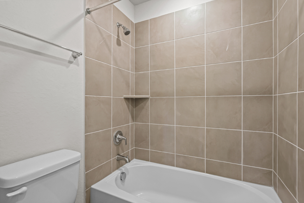 A bathroom with a bathtub and toilet.