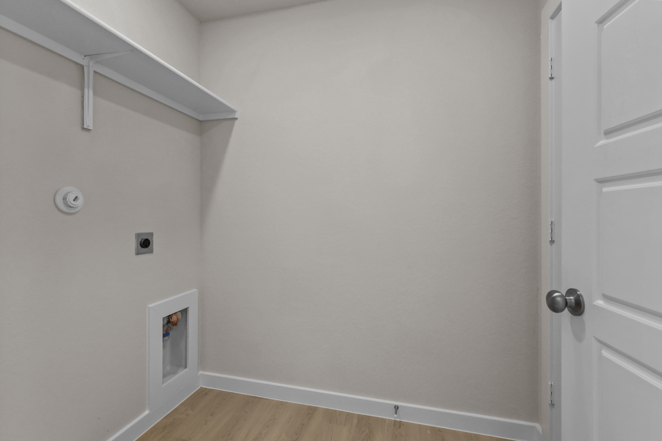 A white wall with a door and a white door.