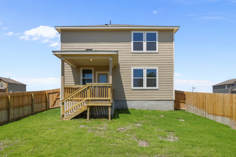 A house with a fence and a wood deck.